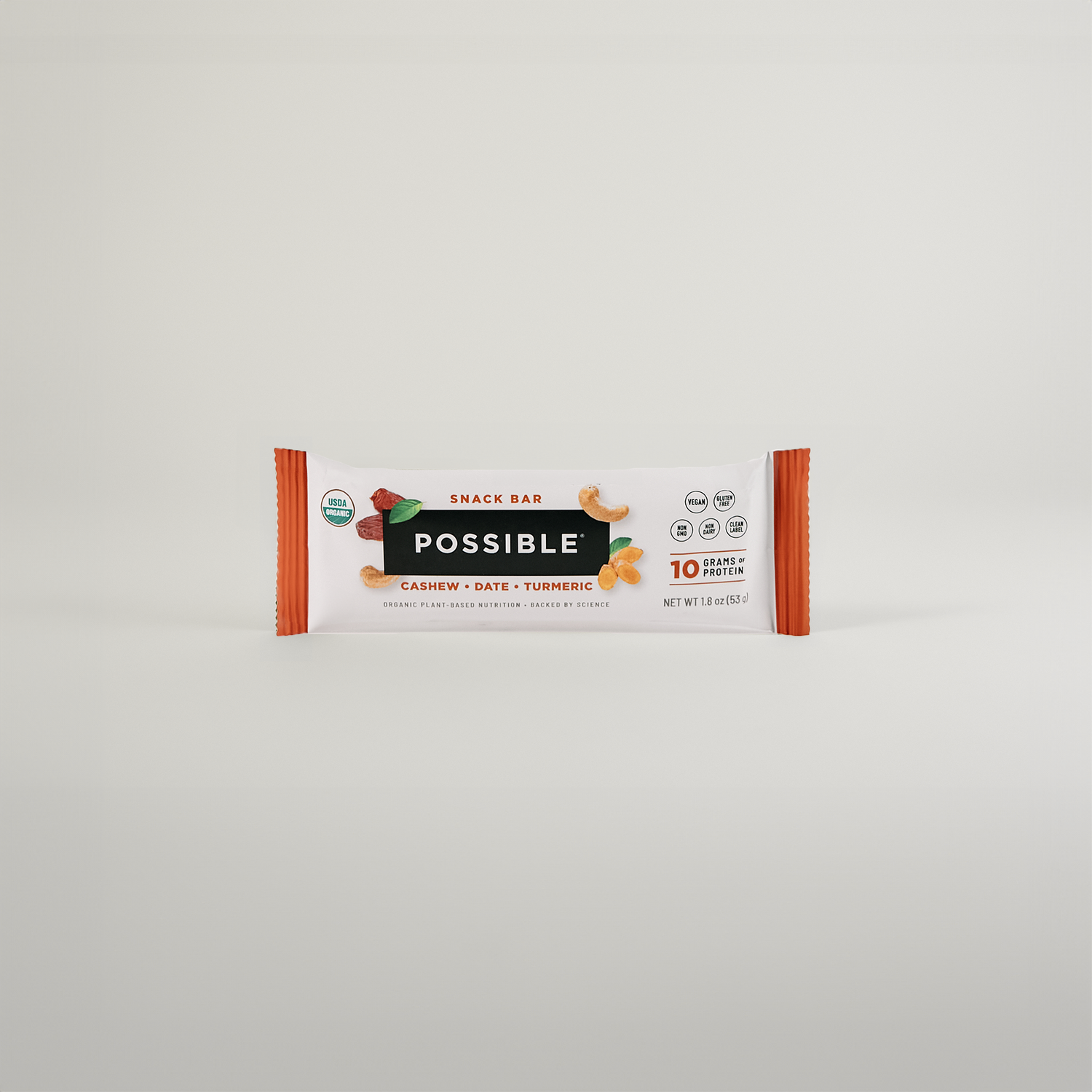 Minimalist display of a cashew turmeric date snack bar in its packaging against a clean white background.