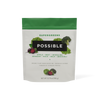 A resealable pouch of POSSIBLE Supergreens powder with a green and white design, featuring images of leafy greens and berries, promoting plant-based nutrition